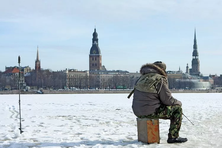 Vecrīgas panorāma un zemledus makšķernieks uz Daugavas.