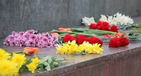 Полицейские убирают цветы с места, где раньше находился памятник в Нарве